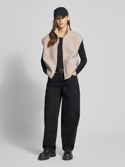 Frauenmodel trägt Regular Fit Weste in Teddyfell-Optik Modell 'SADIA' von Pieces, beige, Strukturmuster, Stehkragen, Ganzkörperansicht von vorne.