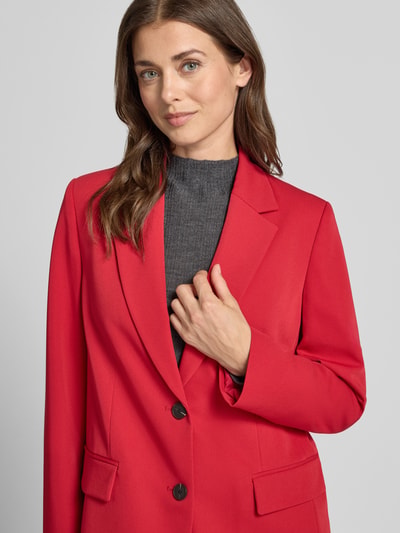 Vrouwenmodel draagt Regular Fit Longline Blazer met Pattentaschen van JAKE*S WOMAN collectie, rood met sierknopen, deelnaad, kraag, schoudervullingen, loopsplit, 2-knoopsluiting, klepzak, lange mouw, Nahaufnahme Oberkörper.