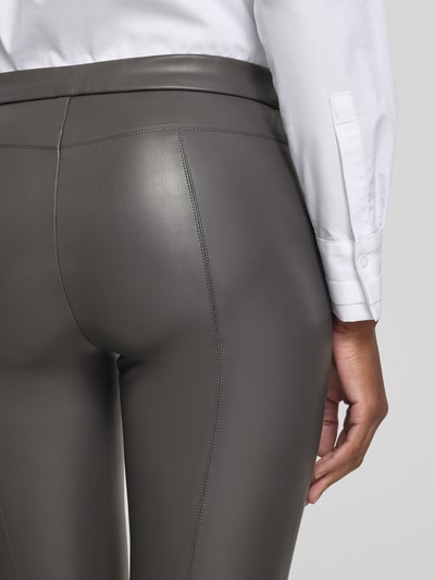 Frauenmodel trägt Skinny Fit Kunstlederhose mit elastischem Bund Modell 'RESA' von Raffaello Rossi in Grau, glatte Oberfläche, Nahaufnahme Rückansicht, Damen Leder- / Kunstlederhose von Raffaello Rossi.