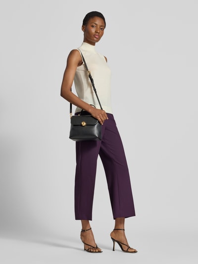 Frauenmodel trägt Shoulder Bag aus echtem Leder Modell 'MOONLIGHT' von FURLA in Schwarz mit Strukturmuster, Ganzkörperansicht von vorne. Das Hauptfach mit Überschlag, Pinschließe, abnehmbarem Schulterriemen und kurzem Tragehenkel ist zu sehen, Maße 25x18x11 cm, mit Innenfach.