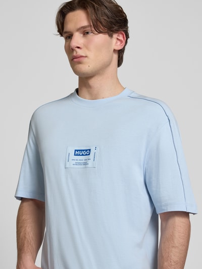 Männermodel trägt Regular Fit T-Shirt aus reiner Baumwolle Modell 'NURAZTI' von Hugo Blue, hellblau, rundhals, Nahaufnahme Oberkörper.