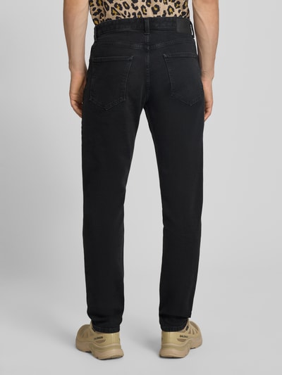 Männermodel trägt Straight Fit Jeans aus Baumwoll-Mix von Marc O'Polo in Schwarz, glatte Textur, Herren Straight Fit Jeans, Ganzkörperansicht Rückansicht.