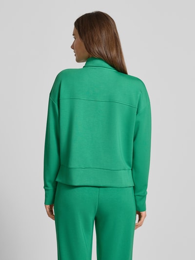 Vrouwenmodel draagt Sweatshirt met Umlegekragen van Christian Berg Woman, groene kleur, losse pasvorm, mix met modal, ribgebreide boorden, korte rits, Ganzkörperansicht Rückansicht.