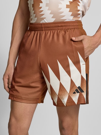 Mannenmodel draagt Regular Fit Sweatshorts met all-over motief van adidas Sportswear, look: all-over motief, regular fit, labelprint, elastische boord, zij-steekzakken; detailopname bovenbeen