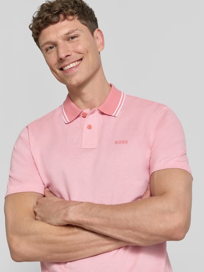 Männermodel trägt Relaxed Fit Poloshirt aus reiner Baumwolle Modell 'PEOXFORDNEW' von BOSS, Mehrfarbig, Logo-Print, 2-Knopf-Verschluss, Ganzkörperansicht von vorne.