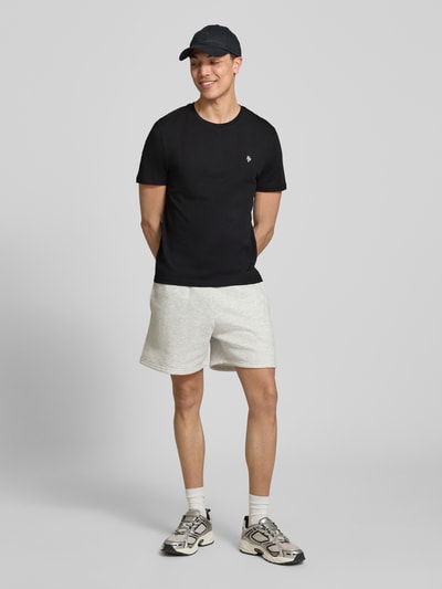 Männermodel trägt Basic Slim Fit T-Shirt mit Flock-Logo auf der Brust von REVIEW, Schwarz, Baumwoll-Viskose-Mix, Rundhalsausschnitt, Herren T-Shirt, Ganzkörperansicht von vorne.