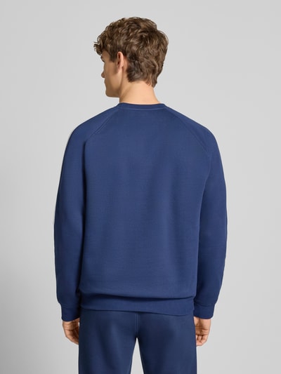 Männermodel trägt Sweatshirt mit Label-Stitching von adidas Originals in Blau, Baumwoll-Mix, Regular Fit, Ganzkörperansicht Rückansicht.