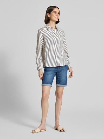 Kobiece modelka nosi Jeansshorts mit Umschlag und elastischem Bund od Angels, bawełna z elastanem, krój regular fit, szerokość w rozmiarze 36: 39 cm, długość nogawki od wewnątrz w rozmiarze 36: 30 cm, kolory: niebieski denim i biel, gładka faktura, widok całej sylwetki z przodu
