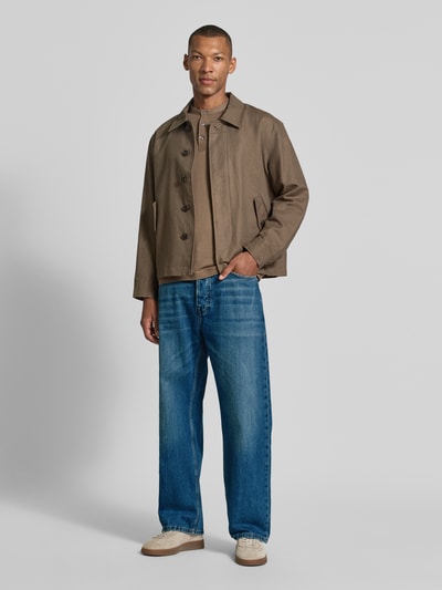 Männermodel trägt Loose Fit Jeans Modell 'THE PITCH' von Scotch & Soda in Blau mit Used-Look, reine Baumwolle, Ganzkörperansicht von vorne.