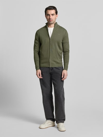 Męski model nosi Regular Fit Strickjacke aus reiner Baumwolle von Tom Tailor, oliwkowa, gładka, ze stójką, długie rękawy, dzianina, bawełna, pełny widok z przodu.