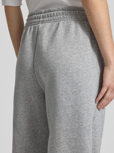 Frauenmodel trägt Loose Fit Sweatpants mit Logo-Stitching Modell 'Phoenix' von Nike aus Baumwoll-Mix, Detailaufnahme Rückansicht, Damen.