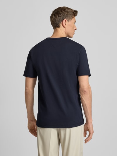 Männermodel trägt Regular Fit T-Shirt aus reiner Baumwolle von Tommy Hilfiger, jednolity granatowy, krótki rękaw, okrągły dekolt, widok z tyłu, Ganzkörperansicht Rückansicht.
