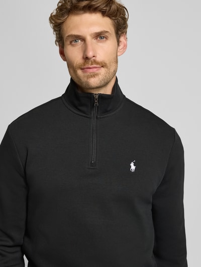 Męski model nosi Regular Fit Troyer aus Baumwoll-Mix von Polo Ralph Lauren, czarny kolor, gładka tekstura, zamek, logo, zbliżenie na górną część ciała.