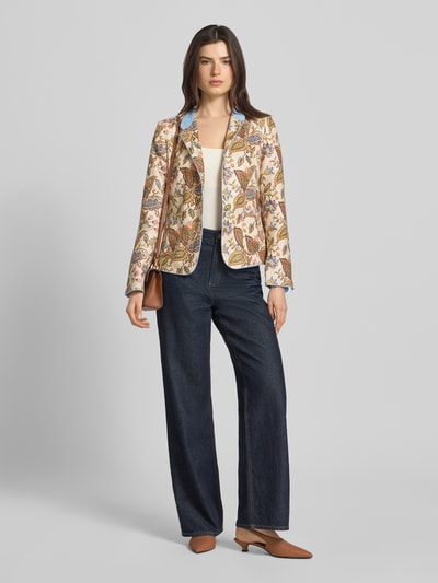 Vrouwenmodel draagt Slim Fit Blazer uit zuiver linnen van WHITE LABEL met all-over bloemenprint, opstaande kraag, opgestikte zakken, knoopsluiting, ruglengte maat 36: 56 cm, borstwijdte maat 36: 44 cm, mouwlengte maat 36: 58 cm, kleurenmix beige, blauw, geel, bruin, materiaaltextuur linnen, bloemenpatroon, geheellichaamsaanzicht van voren.