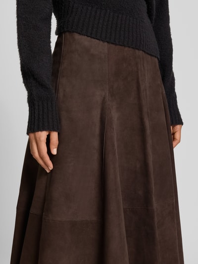 Frauenmodel trägt Midirock aus echtem Leder Modell 'Kilar' von Cph Muse in Dunkelbraun, A-Linie, sichtbare Nähte, Nahaufnahme Oberkörper, Bundweite 38 cm, Gesamtlänge 84 cm.