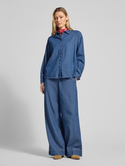Vrouwenmodel draagt Regular Fit Jeanshemd met hemdblouseskraag model 'ARCHER' van ICHI, puur katoen, blauwe kleur, knoopsluiting, volledige lichaamsweergave vooraan.