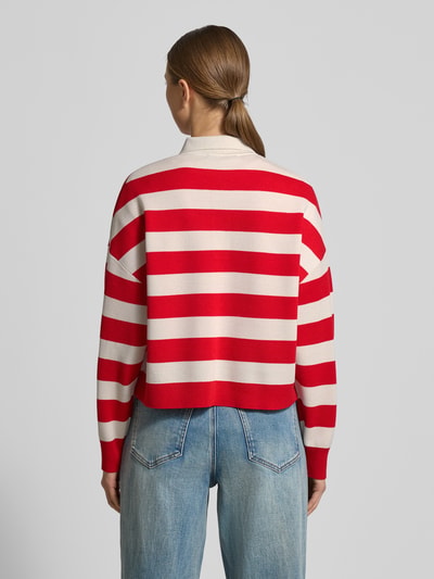 Frauenmodel trägt Regular Fit Longsleeve aus reiner Schurwolle mit Polokragen von Windsor, rot-weiß gestreift, Strick-Optik, Ganzkörperansicht Rückansicht.
