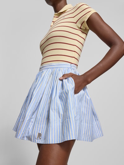 Frauenmodel trägt Minirock aus reiner Baumwolle von Rabanne in A-Linie mit Ziernähte, Label-Detail, gestreiftes Muster, Minilänge, Nahaufnahme Oberkörper.