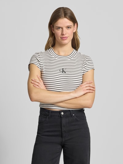 Kobiece modelka nosi Cropped T-Shirt mit Streifenmuster und Logo von Calvin Klein Jeans, mieszanka bawełny i elastanu, wzór w paski, logo, okrągły dekolt, damski t-shirt, długość tyłu w rozmiarze S: 39 cm, widok całej sylwetki z przodu