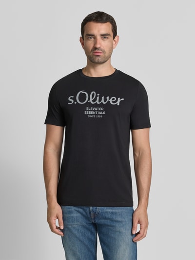 Męski model nosi Regular Fit T-Shirt aus reiner Baumwolle Modell 'BASIC TEE BIG LOGO' von s.Oliver RED LABEL, czarny, gładka faktura, widok z przodu, całe ciało.