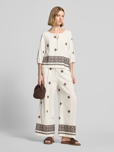 Frauenmodel trägt Hose aus Viskose-Leinen-Mix mit Stitchings von Christian Berg Woman Selection in Creme mit braunen Ziernähten, Regular Fit, elastischer Bund, Musterverlauf am Bein, Ganzkörperansicht von vorne.
