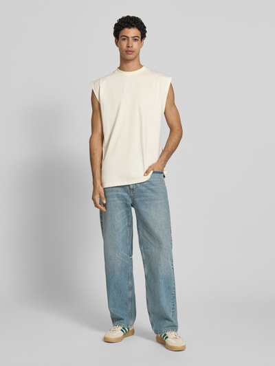 Männermodel trägt T-Shirt mit Label-Stitching von KARL KANI, Herren T-Shirt aus Reine Baumwolle, Relaxed-Fit, Rundhalsausschnitt, Rückenlänge 74 cm, Ganzkörperansicht von vorne.