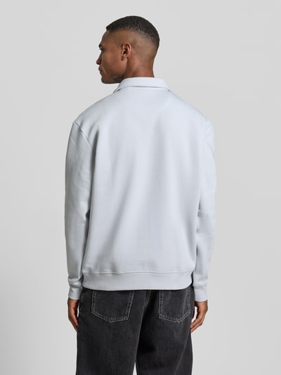 Męski model nosi Koszulkę polo z prążkowanymi wykończeniami od MCNEAL, mieszanka bawełny, luźny krój, kołnierzyk polo, długość tyłu 67 cm, całkowity widok z tyłu.