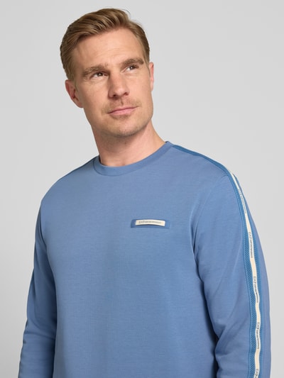 Männermodel trägt Sweatshirt mit Label-Patch und Rundhalsausschnitt von EA7 Emporio Armani, Baumwoll-Mix, Loose-Fit, Nahaufnahme Oberkörper.