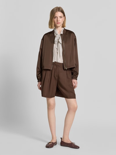 Frauenmodel trägt Bermudas mit französischen Eingrifftaschen von Comma, Lyocell-Mix mit Leinen-Anteil, Loose-Fit, Haken- und Reißverschluss, ganzkörperansicht von vorne.