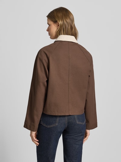 Frauenmodel trägt Regular Fit Jeansjacke aus reiner Baumwolle Modell 'BETT' von Pieces, efekt: jednolity kolor, wykładany kołnierz z obszyciem ze sztruksu, krój regular fit, listwa z zatrzaskami, raglanowe rękawy, kieszenie z patką, wykończenie materiału: denim, materiał: bawełna, Ganzkörperansicht Rückansicht.