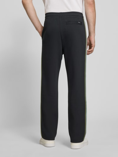 Männermodel trägt Flared Fit Sweatpants aus Baumwoll-Mix von Paul Smith in Dunkelblau mit elastischem Bund, Gesäßtasche, Rückansicht.