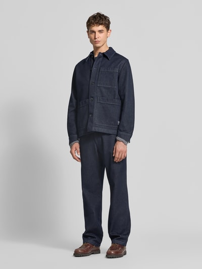 Męski model nosi Regular Fit Jacke aus reiner Baumwolle od Closed, granatowa bawełna, wygląd denimu, kieszenie, guziki, widok całej sylwetki z przodu