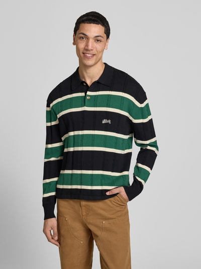 Männermodel trägt Strickpullover mit Polokragen und Label-Stitching von BLKVIS, Reine Baumwolle, Regular-Fit, Zopfmuster, Ganzkörperansicht von vorne.