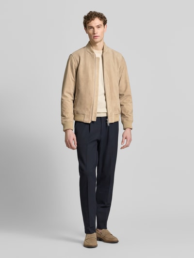 Männermodel trägt Regular Fit Wildlederjacken aus reinem Ziegenleder Modell 'ARCHIVE' von SELECTED HOMME, sandfarben, College-Kragen, Ganzkörperansicht von vorne.
