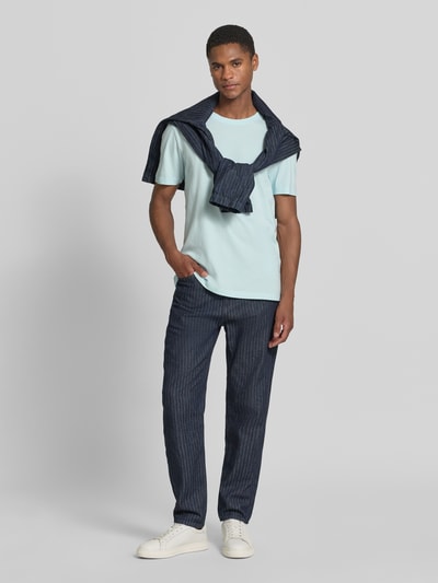 Männermodel trägt Regular Fit T-Shirt aus reiner Baumwolle von s.Oliver RED LABEL in Hellblau, unifarben, kurzarm, Rundhals, Jersey, Ganzkörperansicht von vorne.