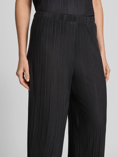Frauenmodel trägt Wide Leg Hose mit Plisseefalten Modell 'PLISA' von Vila, schwarz, Material-Mix mit Viskose-Anteil, Nahaufnahme Oberkörper.