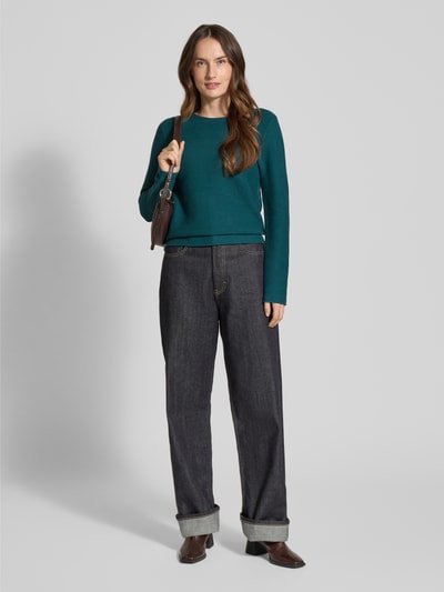 Frauenmodel trägt Regular Fit Strickpullover aus reiner Baumwolle von Tom Tailor, unifarben grün, Rippstrick, Rundhals, Ganzkörperansicht von vorne.