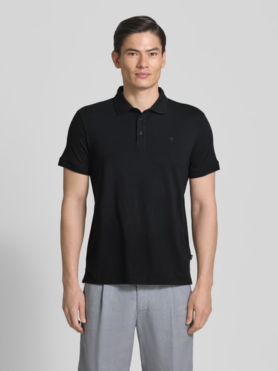 Männermodel trägt Regular Fit Poloshirt mit Knopfleiste Modell 'Carlosjuan' von JOOP! Collection in Schwarz, Obermaterial Baumwoll-Mix mit Stretch-Anteil, Ganzkörperansicht von vorne.