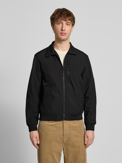 Männermodel trägt schwarze Regular Fit Bomberjacke mit Stehkragen Modell 'Parker' von Jack & Jones, Softshell, Ganzkörperansicht von vorne.