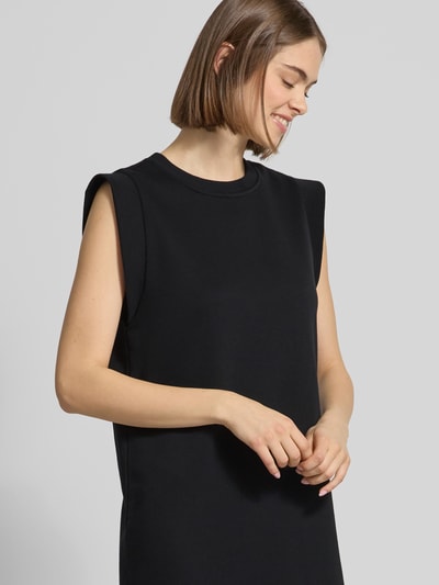 Modelka kobieca nosi czarne Regular Fit Sweatkleid aus Baumwoll-Mix Modell 'CHILLI SUMMER' od Pieces, maxi długość, dzianina, gładka, krój regular fit, okrągły dekolt, bez rękawów, boczne rozcięcia, zbliżenie na górną część ciała z przodu.
