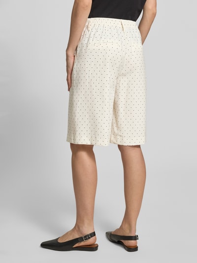 Frauenmodel trägt Bermudas im Allover-Look Modell 'Anja' von FREE/QUENT in Beige mit schwarzen Punkten, weites Bein, elastischer Bund, Paspeltaschen am Gesäß, Ganzkörperansicht Rückansicht.