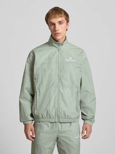 Männermodel trägt Regular Fit Jacke mit Stehkragen Modell 'Nayla' von SERGIO TACCHINI in hellem Grün mit Reißverschluss und Eingrifftaschen, elastische Abschlüsse, Rückenlänge 69 cm, Ärmellänge 61 cm, Ganzkörperansicht von vorne.