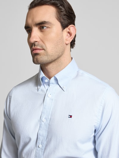Männermodel trägt Regular Fit Freizeithemd aus reiner Baumwolle von Tommy Hilfiger, Optik: unifarben, Nahaufnahme Oberkörper.