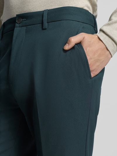 Männermodel trägt Regular Fit Anzughose mit Viskose Anteil von s.Oliver BLACK LABEL in Dunkelgrün, seitliche Eingrifftaschen, Nahaufnahme Oberkörper.