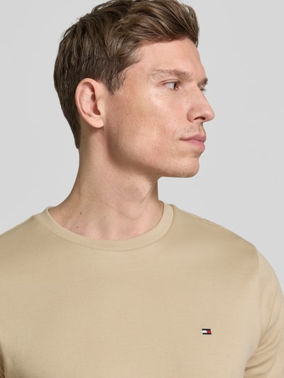 Männermodel trägt Regular Fit T-Shirt aus reiner Baumwolle von Tommy Hilfiger in effen optiek met logodetail, ronde hals, korte mouw, interlook materiaal, Nahaufnahme Oberkörper.