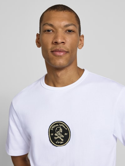 Männermodel trägt Regular Fit T-Shirt aus reiner Baumwolle Modell 'DOBUL' von HUGO in Weiß mit Label Stitching, Nahaufnahme Oberkörper.