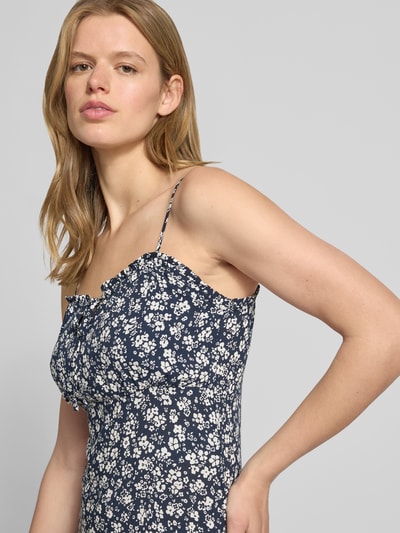 Modelka nosi Schmales Freizeitkleid aus reiner Viskose Modell 'NELLY' od Only, ciemnoniebieska popelina, wzór animal print, krój slim fit, spaghettiträger, z dekoltem Henley, tkanina o gładkiej teksturze, długość midi; zbliżenie na górną część ciała z przodu.
