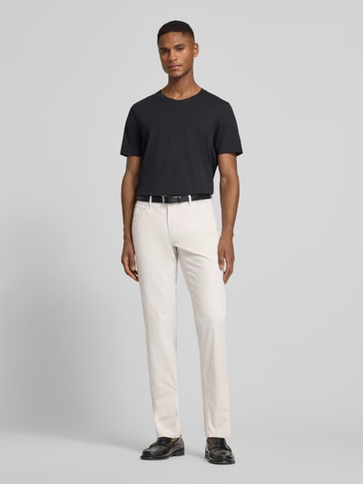 Männermodel trägt Hose mit Eingrifftaschen Modell 'Chuck' von Brax aus Baumwoll-Lyocell-Mix in Slim-Fit, hell, Ganzkörperansicht von vorne.