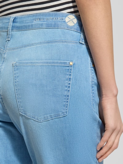 Frauenmodel trägt Bootcut Jeans aus Baumwoll-Mix Modell 'DREAM KICK' von MAC, 5-Pocket-Design in hellem Blau, Detailaufnahme Rückansicht.