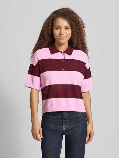 Frauenmodel trägt Regular Fit Poloshirt aus Baumwoll-Mix von Marc O'Polo Denim, Optik:Allover-Muster mit Blockstreifen, Frottee-Textur, V-Ausschnitt, Polokragen, Knopfleiste, Kurzarm, Ärmelabschluss gerippt, Farbmix aus Rosa und Bordeaux, Ganzkörperansicht von vorne.